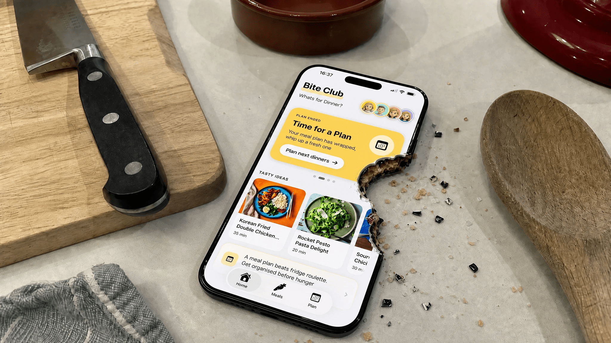iPhone on a kitchen counter showing the Bite Club app — Whats for Dinner home screen in warm kitchen light